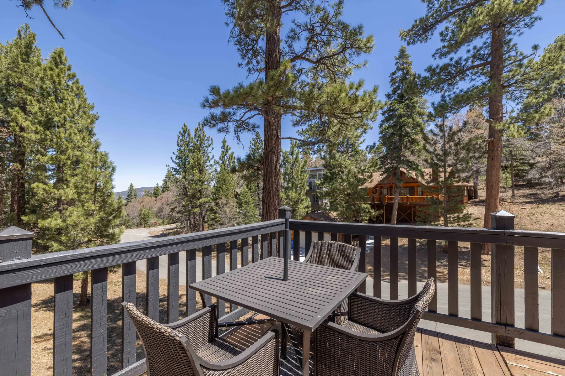 Hot tub on the wraparound deck at Pine Grove Cabin with deck seating and mountain views in the background