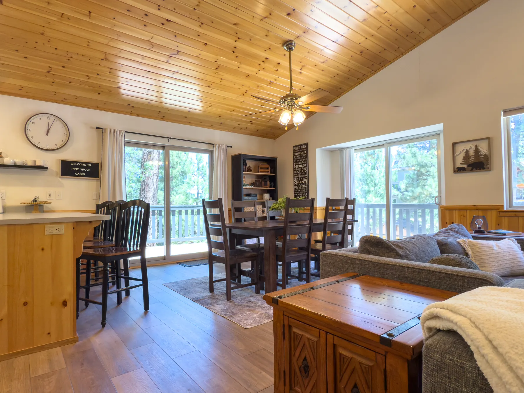 Dining table at Pine Grove Cabin seating six, next to the kitchen breakfast bar